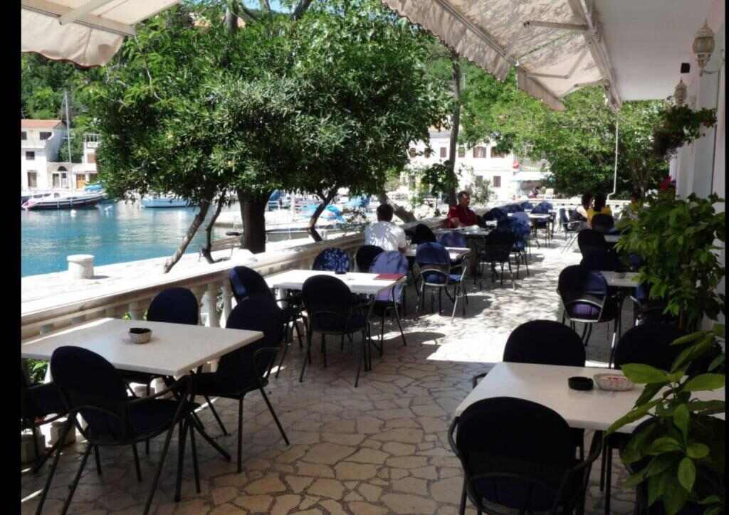 Shaded seaside terrace with tables looking over the harbour of Jablanac