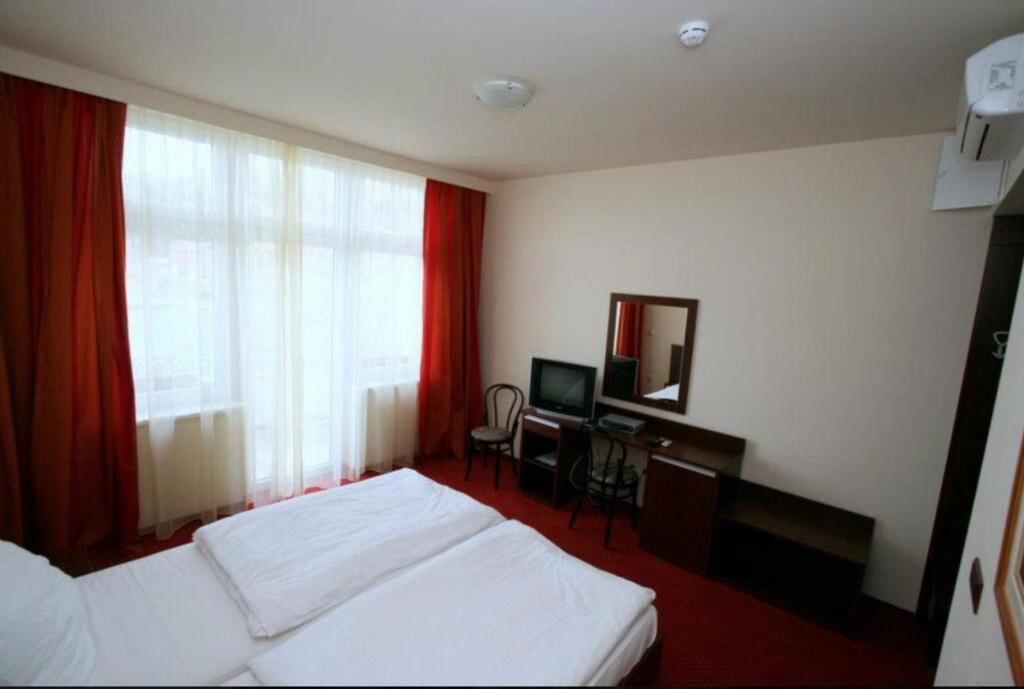 Hotel room with sea view window, twin beds and a work desk